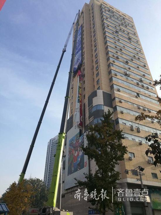 青岛第一高楼体广告被拆，两台300吨吊车助力